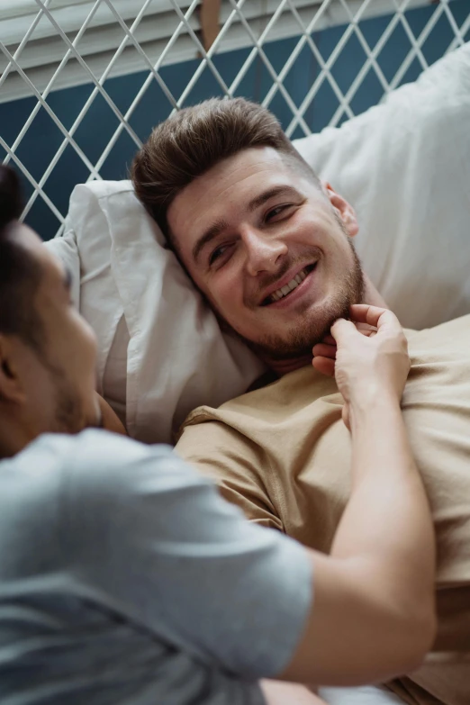 a man laying in bed next to a woman, trending on reddit, lgbtq, reaching out to each other, two young men, smiling at each other