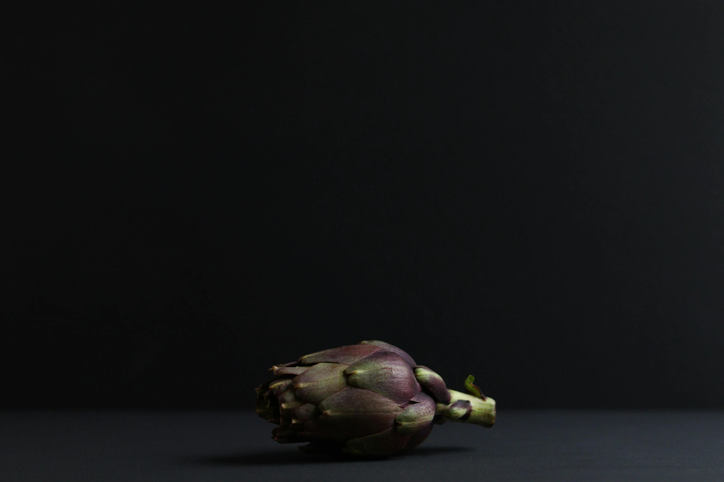 an artichoke sitting on top of a table, by Martin Desjardins, black backdrop, ignant, vesa-matti loiri, ffffound