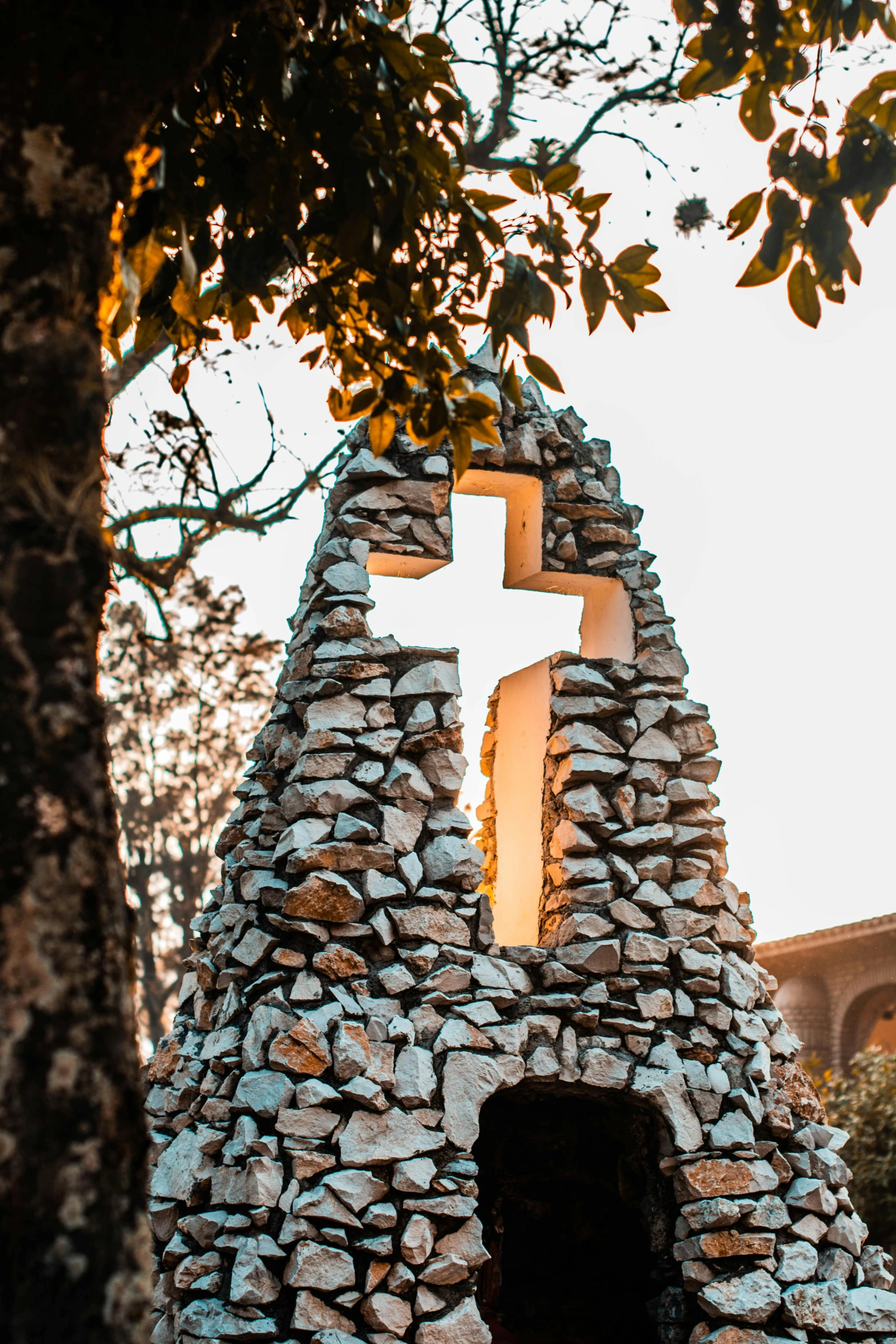 a stone church with a cross on top of it, by Carlo Carrà, napa, public art, beautifully soft lit, rocks