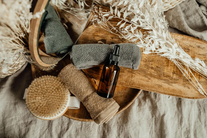 a wooden tray topped with a bottle of lotion and a brush, by Emma Andijewska, trending on pexels, cloth wraps, brown, sustainable, thumbnail