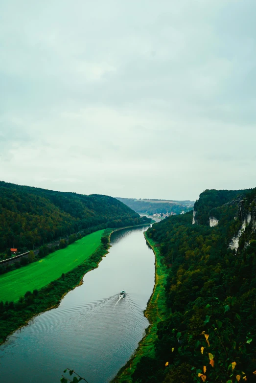 a river running through a lush green valley, an album cover, pexels contest winner, german romanticism, white, wide high angle view, cliffside, red river