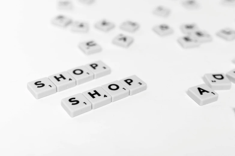 a bunch of letters sitting on top of a table, lots of shops, with a white background, word, product photograph