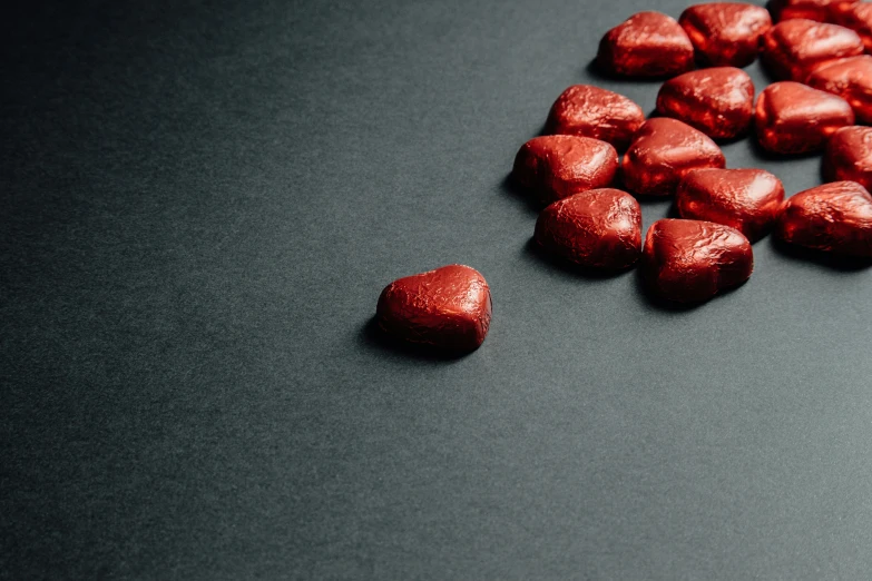 a pile of chocolate hearts sitting on top of a table, pexels contest winner, hyperrealism, metallic red, slate, thumbnail, high-resolution