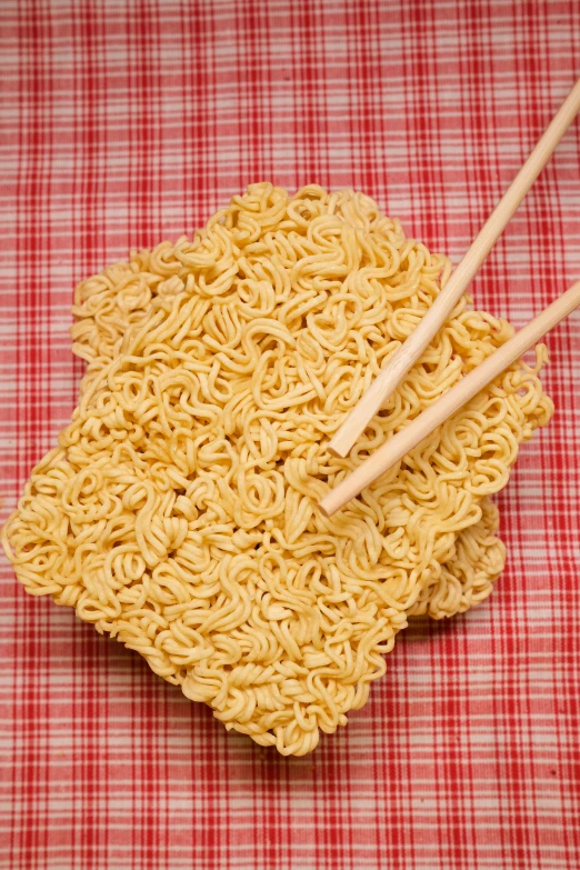 a bowl of noodles with chopsticks on a red and white checkered table cloth, pexels, dau-al-set, square, body made out of macaroni, 3 - piece, super detailed image