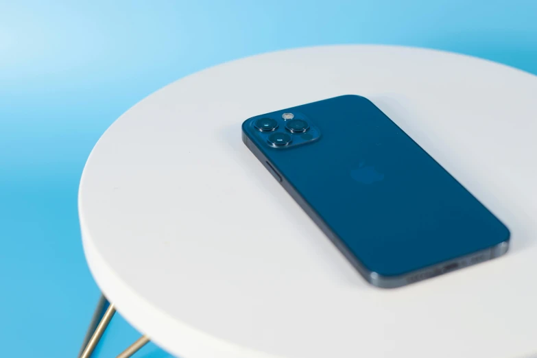 a blue iphone sitting on top of a white table, trending on pexels, taken in 2022, square, uk, blue backdrop