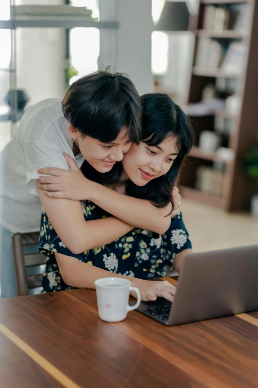 a man and woman hugging each other in front of a laptop, trending on pexels, happening, asian women, lesbian, indonesia, avatar image