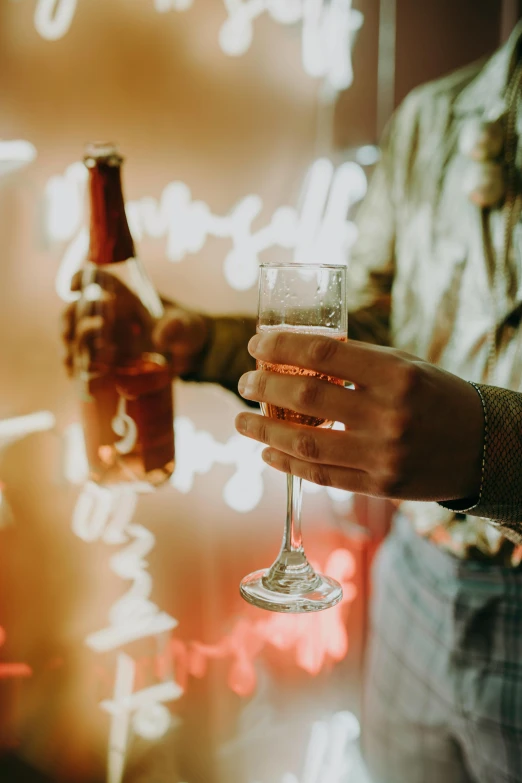 a close up of a person holding a wine glass, beer, bubbly, glow, holding a bottle