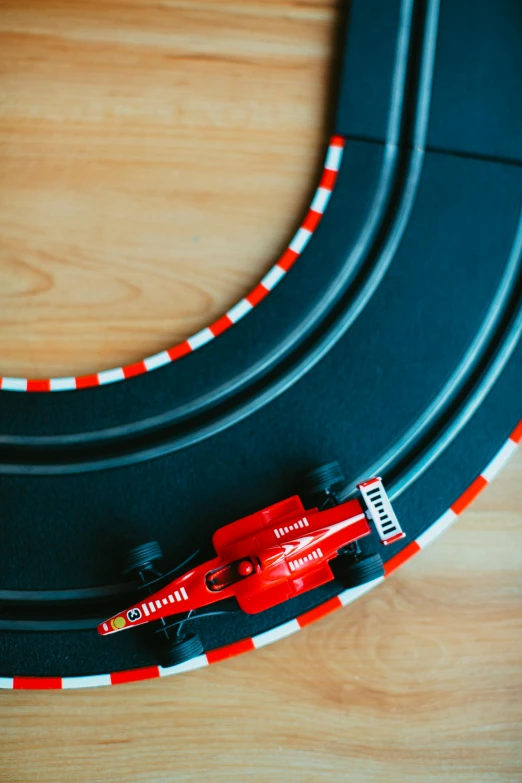 a toy race track with a red car on it, by Matthias Stom, unsplash, turntables, soft vinyl, f 1/3, circular