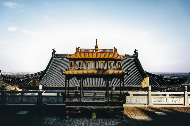 a view of a building from the top of a hill, unsplash contest winner, cloisonnism, gold and black color scheme, pavilion, square, chinese costume