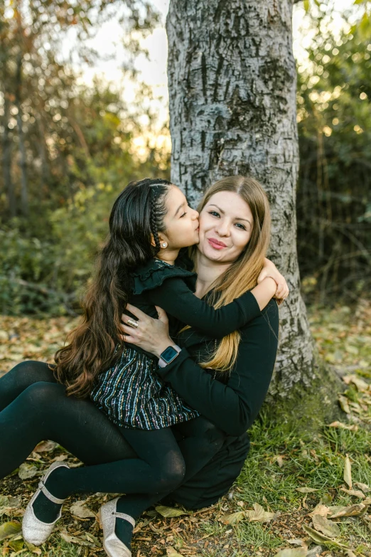 a mother hugging her daughter in front of a tree, profile image, miranda cosgrove, portrait image, f / 1. 8