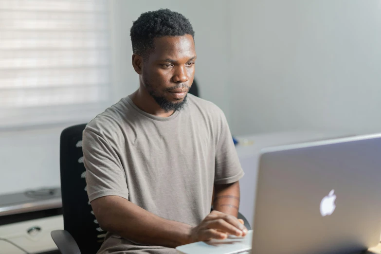 a man sitting in front of a laptop computer, pexels contest winner, emmanuel shiru, chris tulloch mccabe, official screenshot, concentration