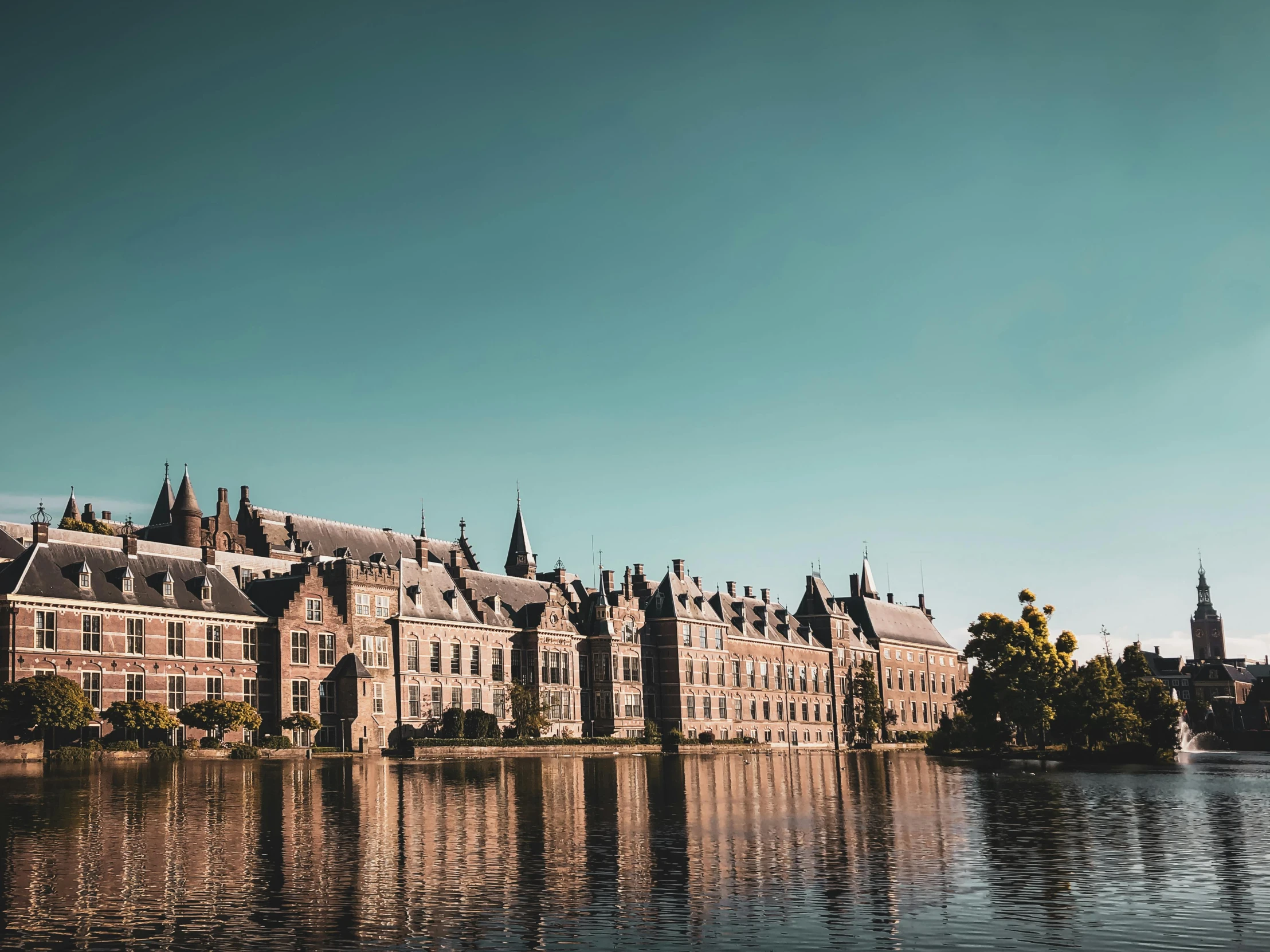 a large building next to a body of water, by Jacob Toorenvliet, pexels contest winner, baroque, helmond, hogwarts style, sharp high quality photo, brown