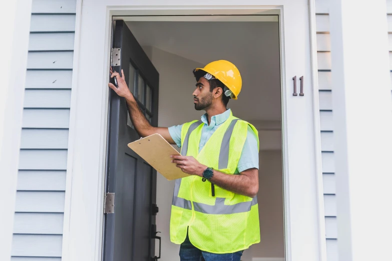 a man in a yellow safety vest holding a clipboard, a photo, pexels contest winner, about to enter doorframe, in front of a two story house, listing image, thumbnail