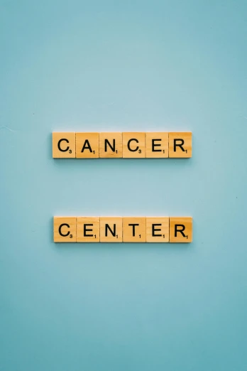 wooden scrabbles spelling cancer center on a blue background, a cartoon, shutterstock, color graded, 2070s, sun, shot on canon eos r5