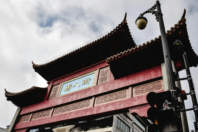 a street light in front of a red building, inspired by An Zhengwen, trending on unsplash, cloisonnism, intricate detailed roof, square, advertising photo, archway
