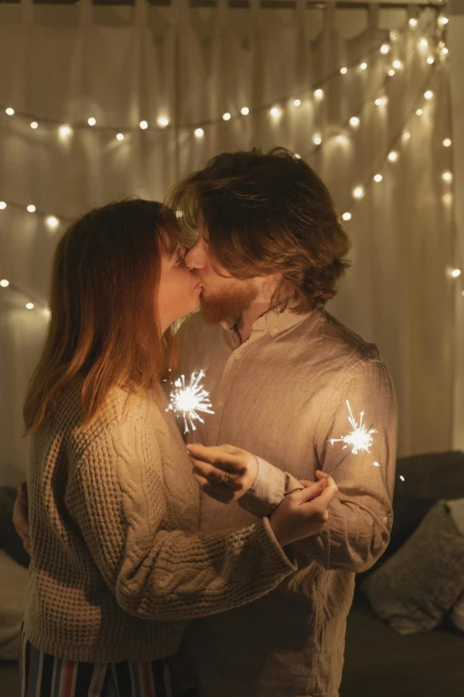 a man and a woman holding sparklers in their hands, pexels contest winner, romanticism, kissing together cutely, at home, promo image, cozy lights