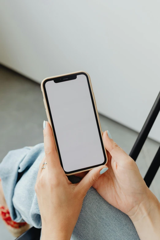 a woman sitting in a chair holding a cell phone, trending on pexels, rounded corners, modern minimalist f 2 0 clean, no - text no - logo, ios app icon