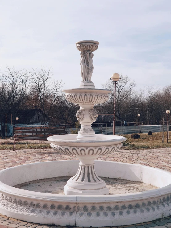 a white fountain sitting in the middle of a park, 165 cm tall, romanian heritage, high-quality render, white stone