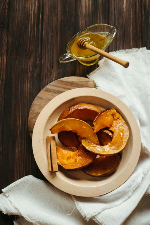 a bowl that has some kind of food in it, a still life, by Julia Pishtar, unsplash, pumpkin, cinnamon, honey, square