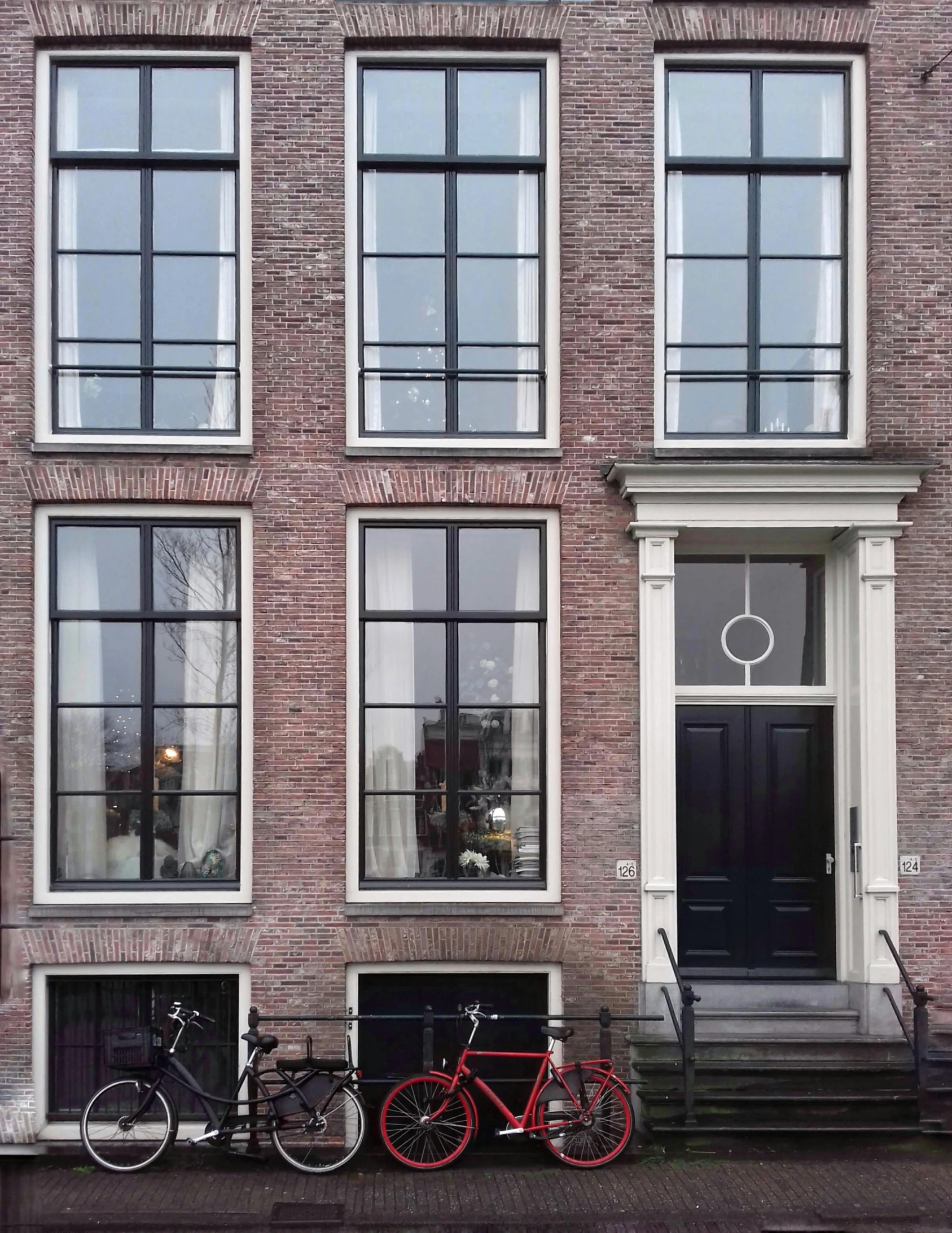 a couple of bikes are parked in front of a building, black windows, dutch masterpiece, doors to various bedrooms, 2019 trending photo