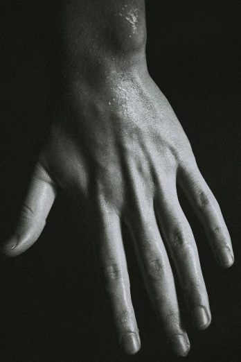 a black and white photo of a person's hand, inspired by Robert Mapplethorpe, unsplash, hyperrealism, sweaty skin, on a dark background, ignant, resin