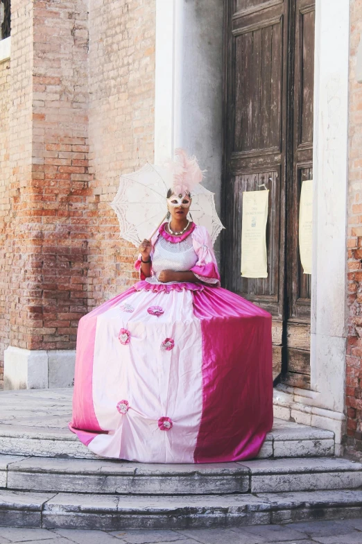 a woman in a pink dress sitting on the steps of a building, an album cover, inspired by Fra Bartolomeo, pexels contest winner, renaissance, intricate clown costume, ( ( dark skin ) ), white and pink cloth, venice