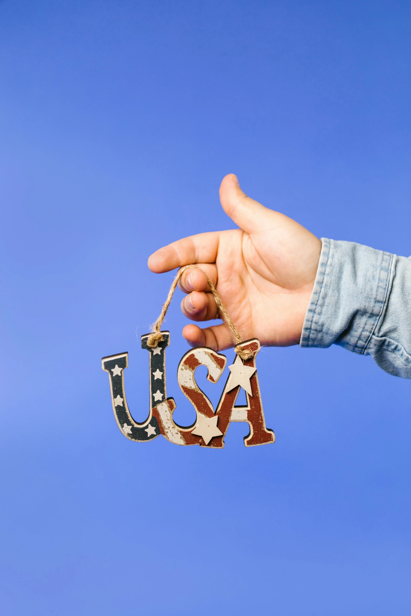 a person holding a usa ornament in their hand, by Julia Pishtar, ultra high resolution, shot on sony a 7, wooden decoration, high resolution