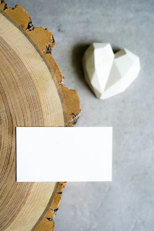 a business card sitting on top of a piece of wood, a marble sculpture, pexels contest winner, hearts, matte white paint, papercraft, no - text no - logo