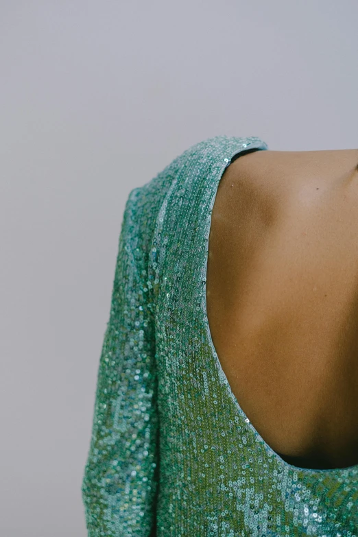 the back of a woman wearing a green sequinned top, inspired by Elsa Bleda, trending on pexels, seafoam green, made of lab tissue, detail shot, iridiscent fabric