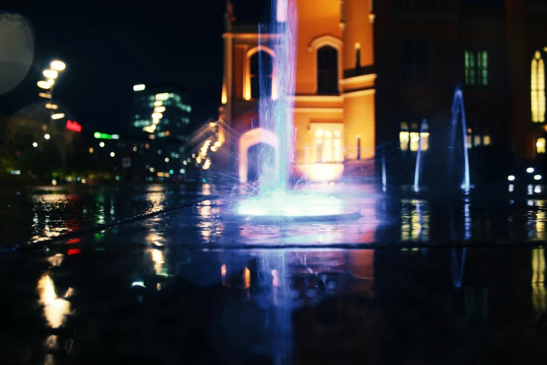 a fountain in the middle of a city at night, a picture, unsplash contest winner, art photography, medium format. soft light, bokeh ), architecture photo, spooky photo