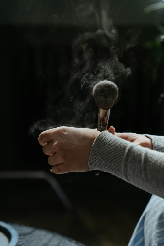 a person sitting on a couch smoking a cigarette, an album cover, pexels contest winner, purism, scales with magic powder, hairy arms, holding brush, grey