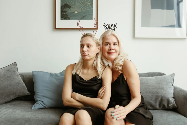 a couple of women sitting on top of a couch, by Emma Andijewska, pexels contest winner, crown on head, thin aged 2 5, blonde swedish woman, my mom is going to be so mad