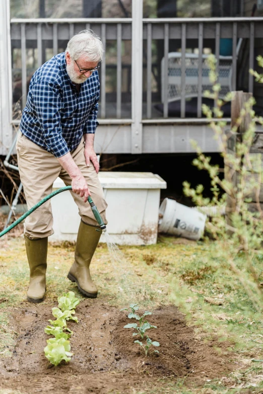 a man that is standing in the dirt with a hose, in a garden, planters, profile image, clogs