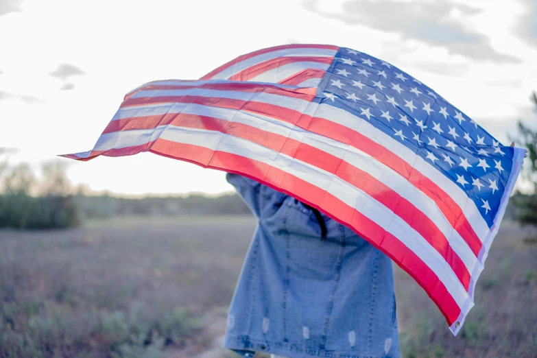 a person holding an american flag over their head, pexels contest winner, single person with umbrella, background image, avatar image, united states