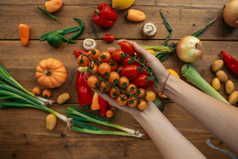 a person holding a bunch of vegetables on a table, profile image, background image, uncrop, green and orange theme