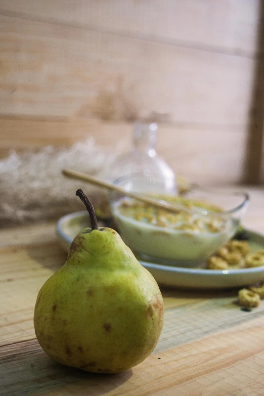 a pear sitting on top of a wooden table, a still life, inspired by Cornelis Pietersz Bega, pexels, cereal, served with pasta, square, made of glazed