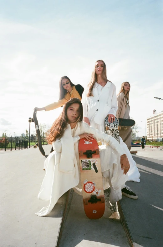 a group of women sitting on top of a skateboard, a picture, by Nina Hamnett, trending on unsplash, gutai group, wearing white suit, paris fashion week, official store photo, on the tennis coat