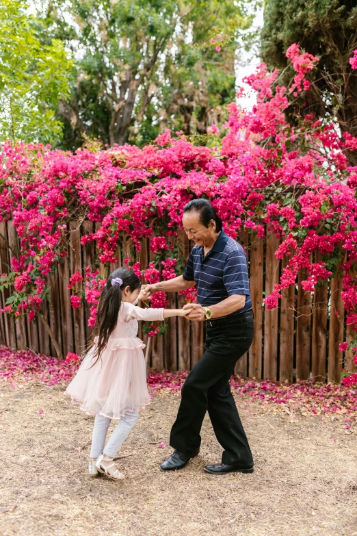 a man and a little girl playing with a frisbee, an album cover, pexels contest winner, arabesque, bougainvillea, in japanese garden, chile, dancing gracefully
