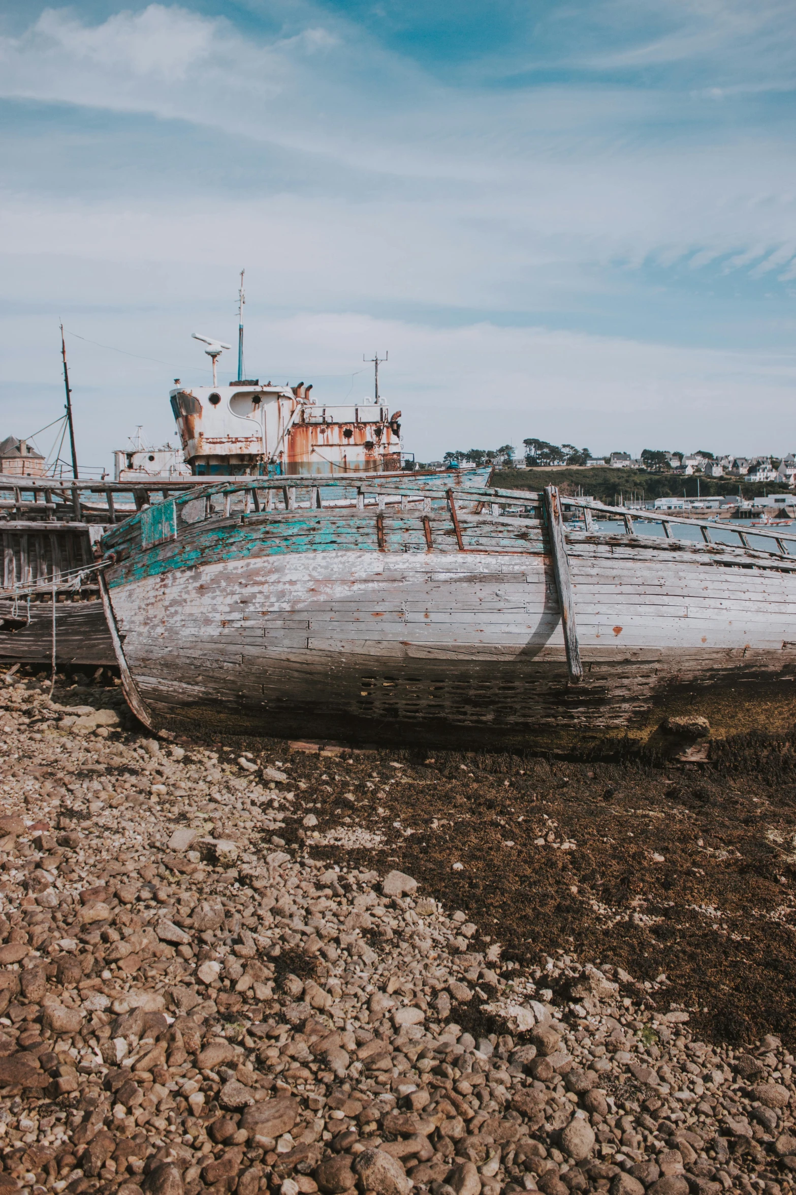 a boat sitting on top of a rocky beach, unsplash, auto-destructive art, old wooden ship, building crumbling, low quality photo, reykjavik