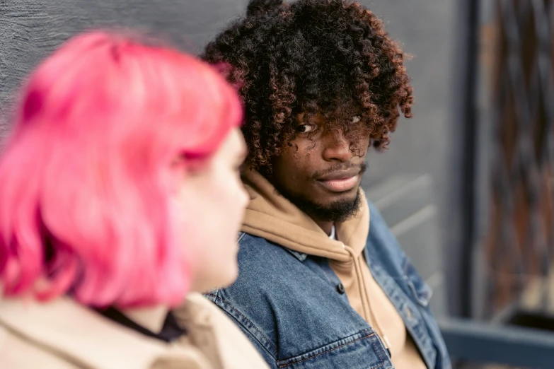 a man and a woman standing next to each other, trending on pexels, curly pink hair, dark people discussing, black teenage boy, a photo of a disheveled man