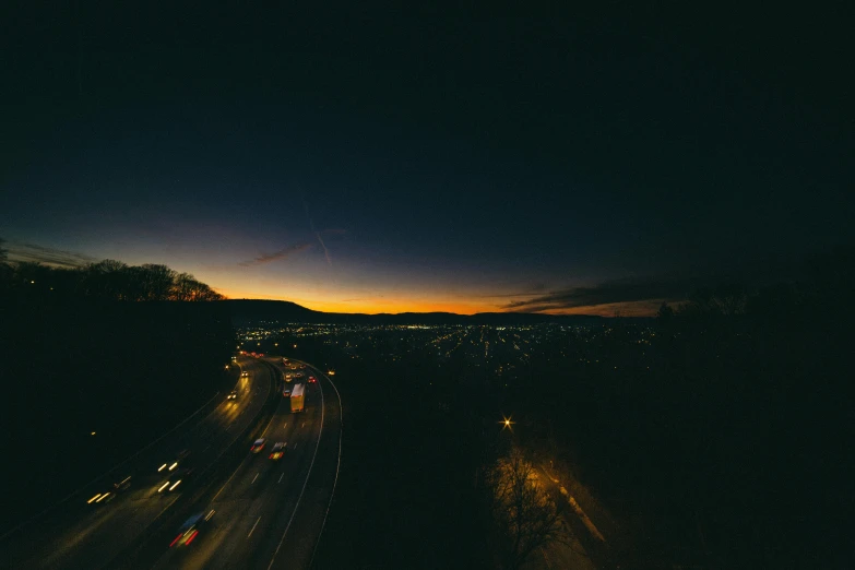 an aerial view of a highway at night, pexels contest winner, sunset in a valley, photo of zurich, high quality photo, dark cityscape