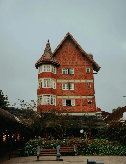 a red and white building with a bench in front of it, a photo, unsplash contest winner, art nouveau, enchanted forest tower, colombia, on a rainy day, restaurant!