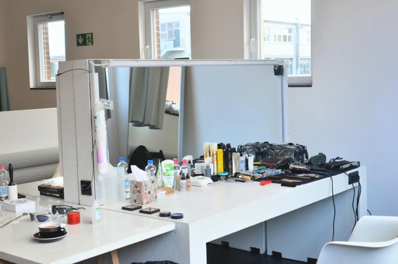 a white desk topped with a mirror next to a white chair, theatre equipment, model agency, engineering bay, profile image
