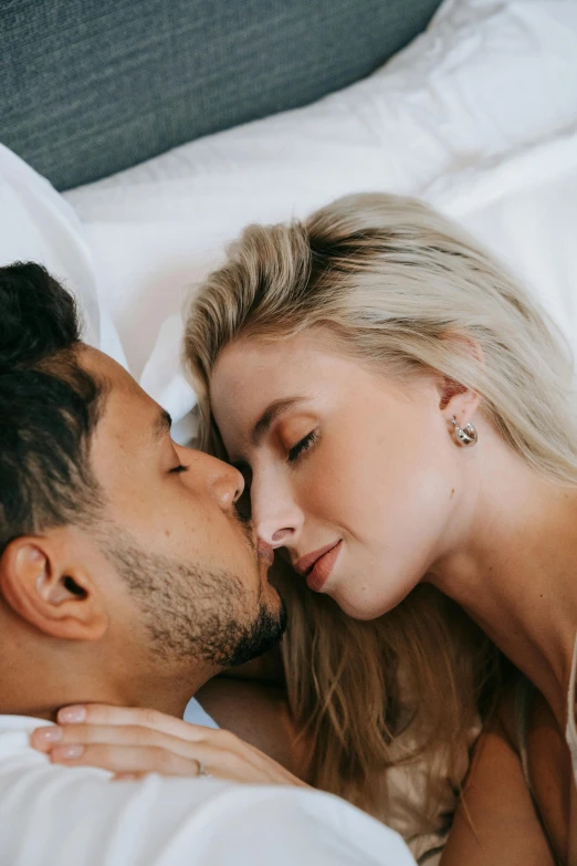 a man and woman laying in bed next to each other, trending on pexels, kiss mouth to mouth, profile shot, blonde, manuka