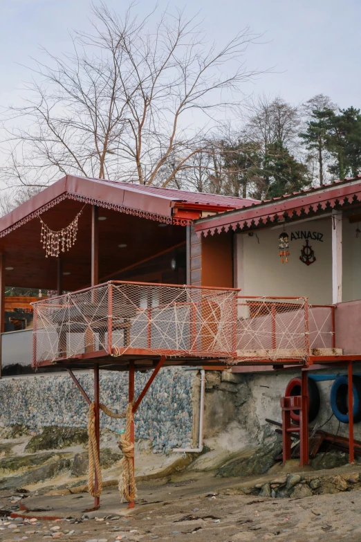 a couple of houses sitting on top of a sandy beach, danube school, behind bar deck with bear mugs, sangyeob park, awnings, snow monkeys at the mountain spa