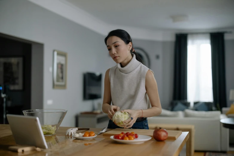 a woman standing in a kitchen preparing food, inspired by Li Di, pexels contest winner, home video footage, portrait of a starving ai artist, people watching around, attractive photo