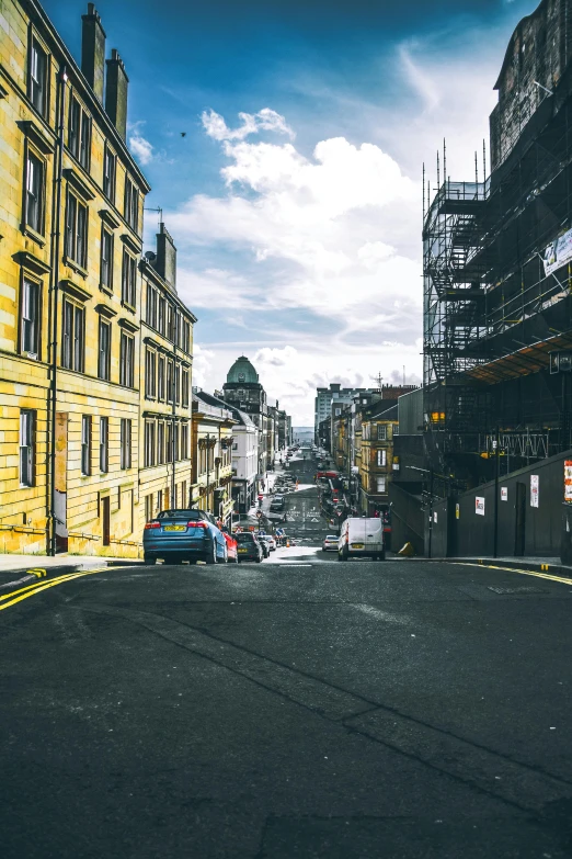 a street filled with lots of traffic next to tall buildings, a photo, pexels contest winner, renaissance, in scotland, built on a steep hill, yellow, streetwear