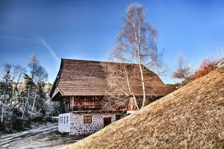 a house sitting on top of a hill next to a forest, by Thomas Häfner, pexels contest winner, renaissance, barn, sunny winter day, museum photo, thumbnail