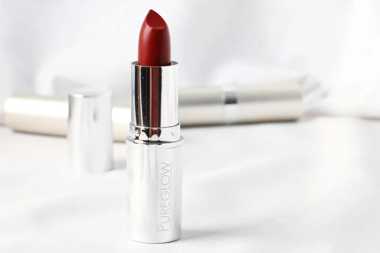a red lipstick sitting on top of a white table, arcane glow, full product shot, silver crown, 'groovy'