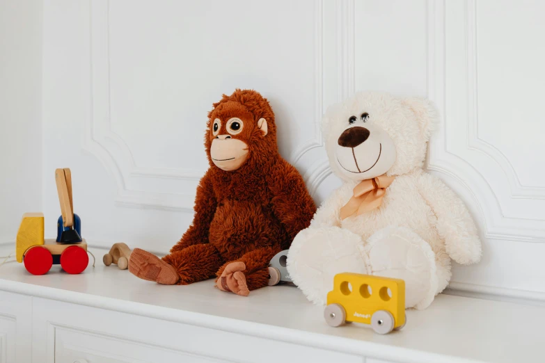 two stuffed animals sitting next to each other on a shelf, pexels, orangutan, detailed product image, childs bedroom, chocolate